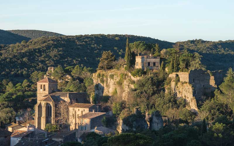Le village de Mourèze accroché à la colline à
                  l'orée du Cirque