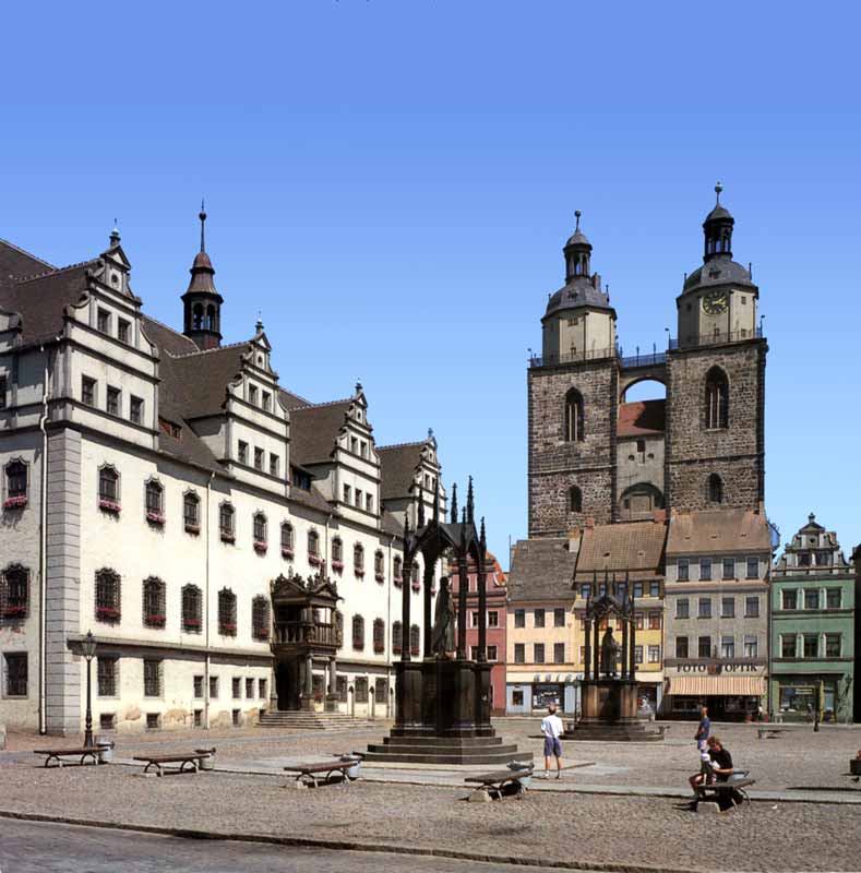 Wittenberg: sur la Marktplatz , le Rathaus et les
                statues de Luther et Melanchton; en arrière les tours de
                Marienkirke