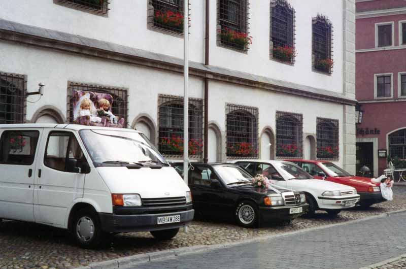 Voitures décorées attendant les nouveaux mariés
                devant le Rathaus