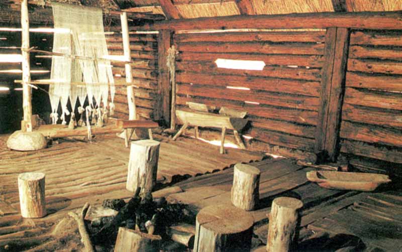 Intérieur d'une maison de Biskupin avec âtre,
                      métier à tisser et bac à pain