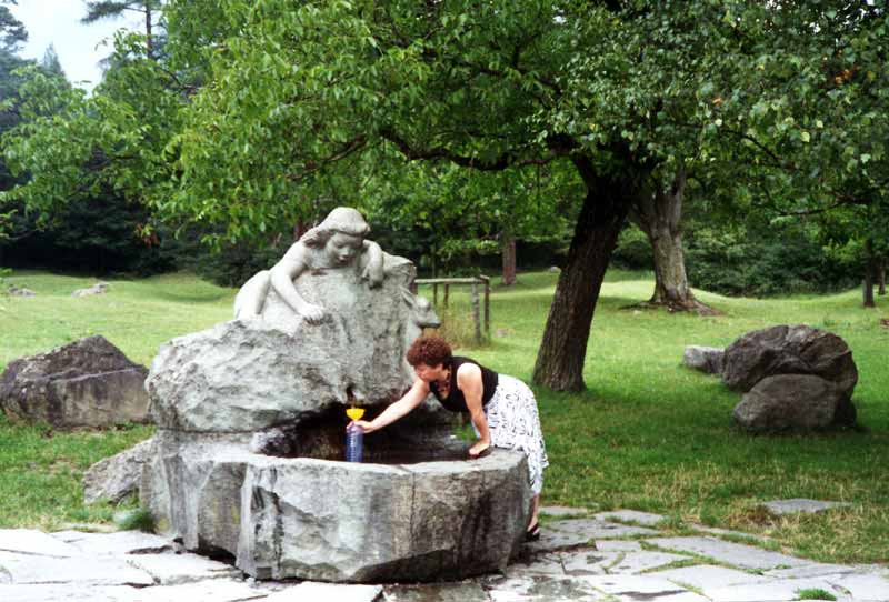 Monique remplit quelques bouteilles à la fontaine
                  de Heidi