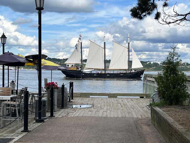 Dans le port d'Halifax, goélette de pêche passant
            devant le quai